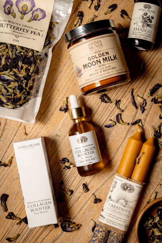 Anima Mundi skincare and wellness products on a wooden surface with dried flowers and herbs.